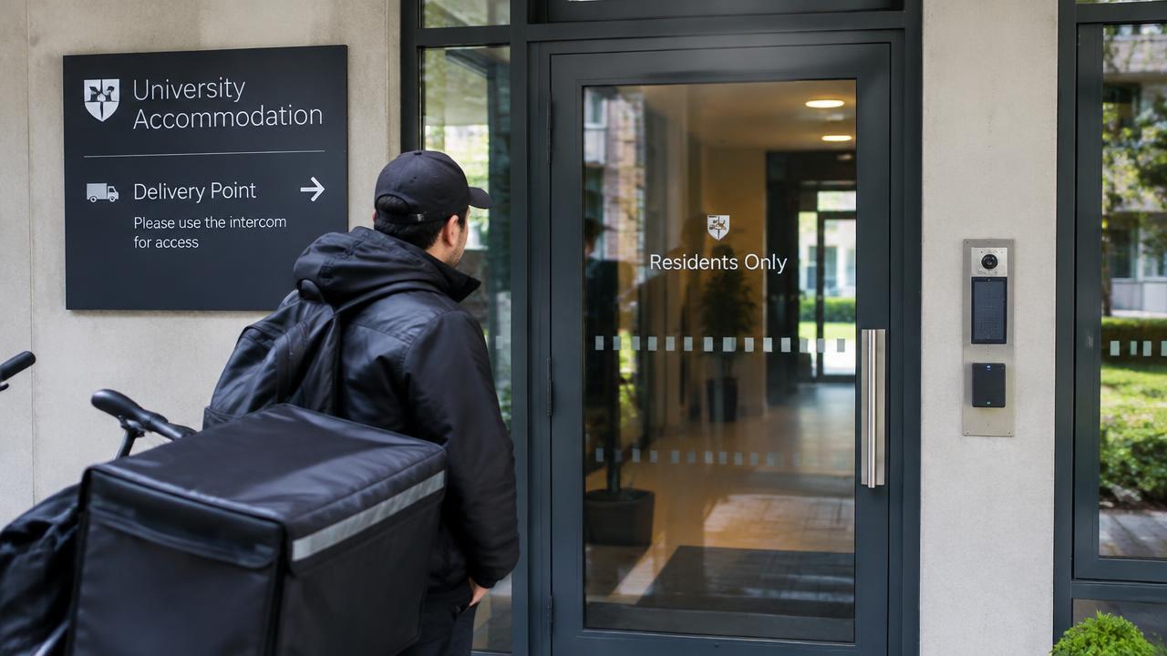 Delivery rider waiting outside a residents-only university accommodation door next to a delivery point sign