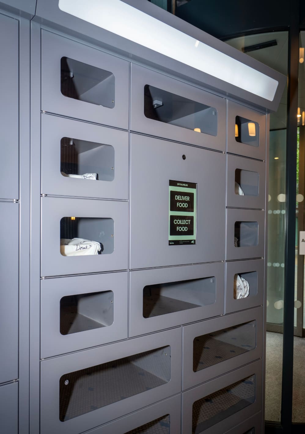 Heated food delivery lockers installed in a modern apartment building lobby